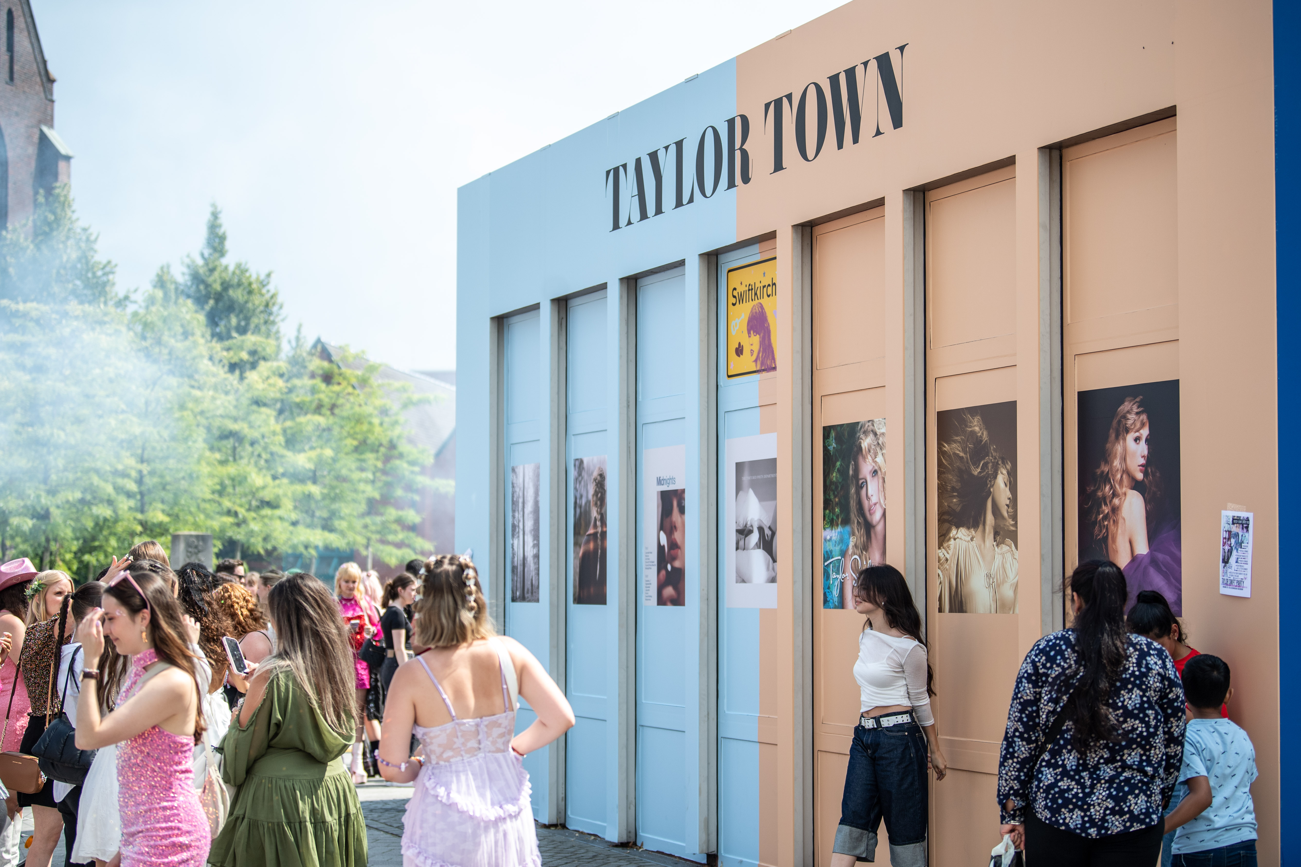 Fans von Taylor Swift machen Fotos vor Plakaten.