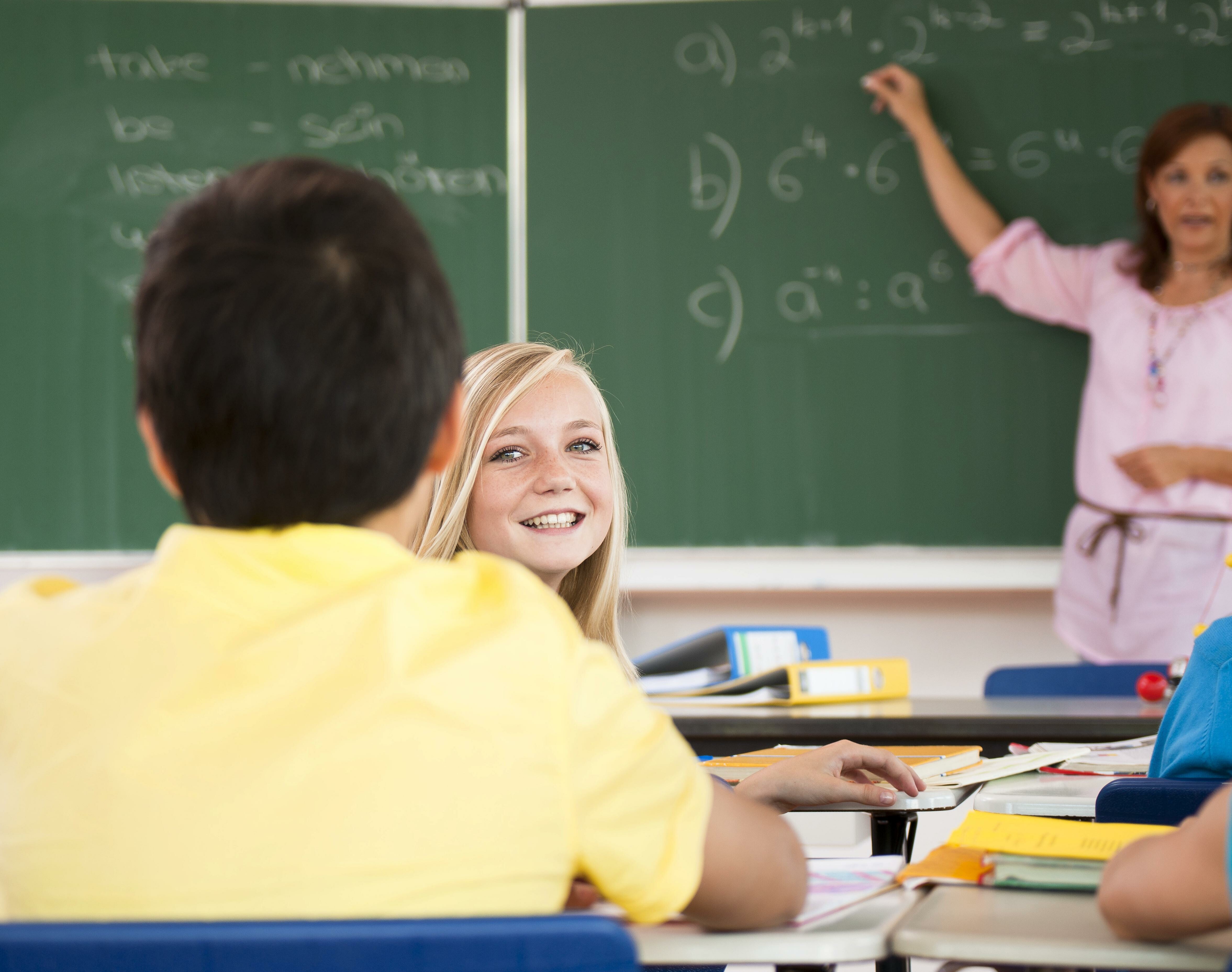 Schülerin dreht sich im Unterricht zu Klassenkameraden um