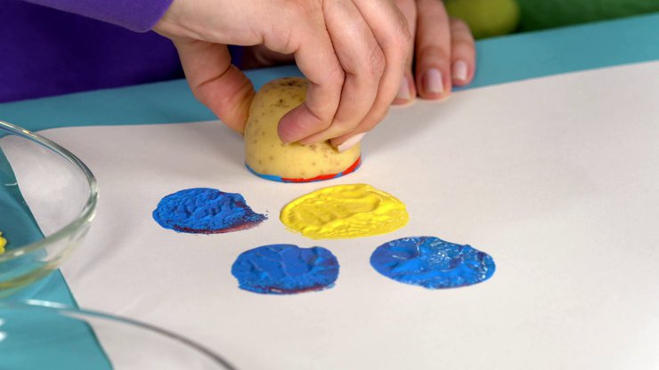 Tanja druckt nah mit gelb auf das Papier