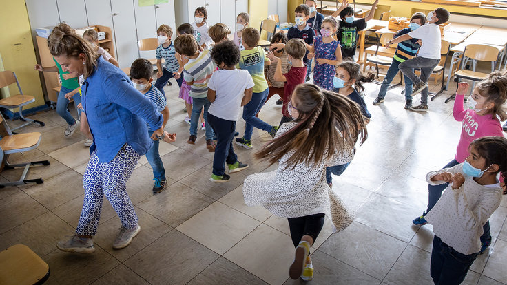 Lehrerin tanzt mit den Kindern ihrer Klasse 