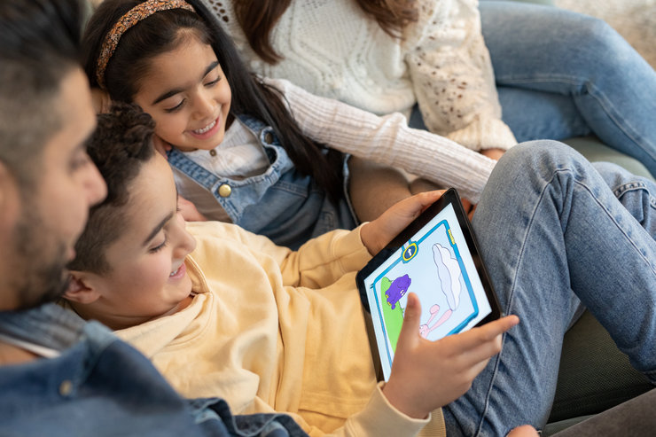 Zwei lachende Kinder mit Tablet, darauf Wenn-Dann-Maschine mit Elefant und Hase