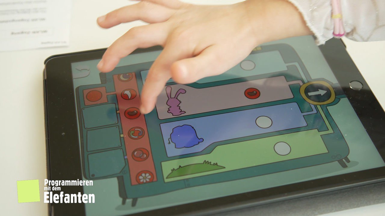 Wenn-Dann-Maschine mit Elefant und Hase auf dem Tablet, Finger eines Kindes tippen darauf